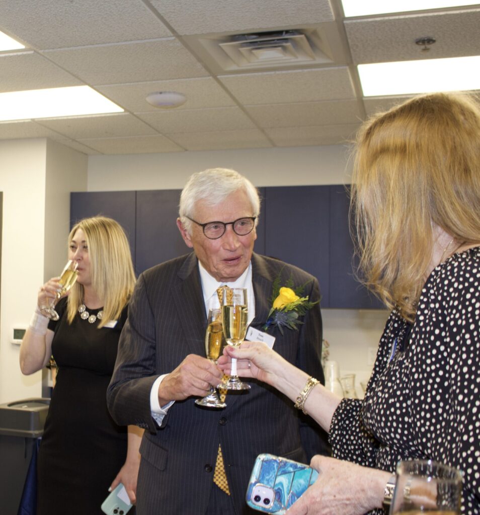 Tom Beach enjoys a champagne toast during the ribbon-cutting event.